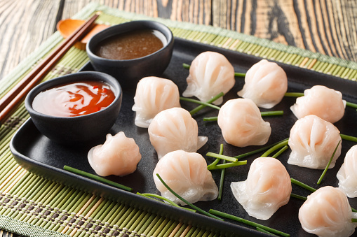 Traditional chinese steamed dumplings Dim Sums Har gow with shrimp served with sauce closeup on the table. Horizontal