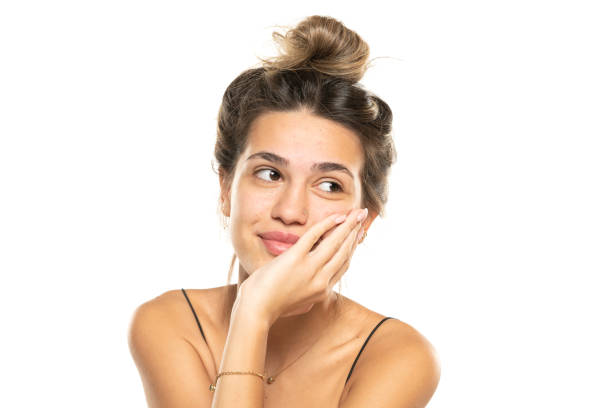 istock smiling woman with messy loose bun and no makeup on a white studio background. front view 1596436086