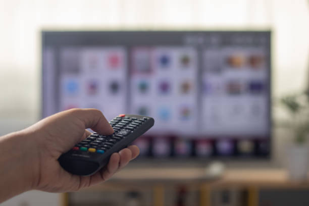 istock The man is watching TV and using a remote control to search for a program on the internet. 1596446534