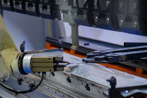 Close up the sheet metal bending process by robotic arm. The automatic material handling the sheet metal parts by robotic system.