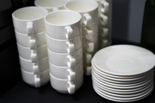 many clean white cups and plates on the table