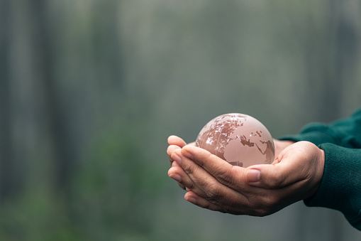 Concept of the Environment World Earth Day. Environment Earth Day In the hands holding green earth on green Background, Saving environment, and environmentally sustainable. Save Earth.