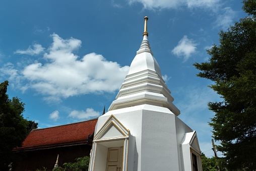 A low angle shot of a white pagoda roof under a bright blue sky