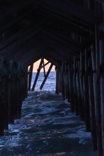 Pawley's Island, South Carolina - The view under the fishing pier at sunrise showing damage from Hurricane Ian which took half of the pier out to sea.
