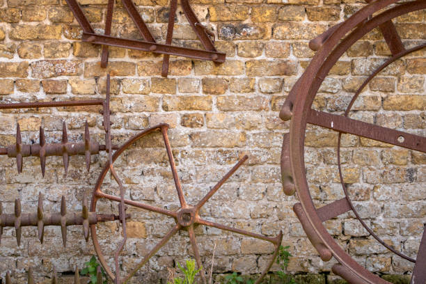 istock Old wheels and tools on a farm's wall 1596599452