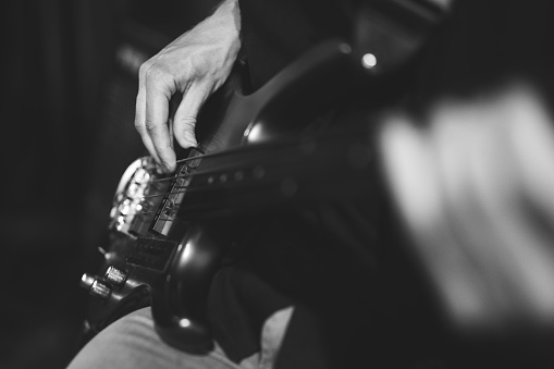 hands of a guitarist, a musician plays the bass guitar