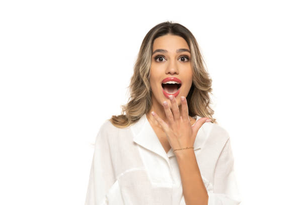 beautiful young surprised happy women with makeup and long wavy hair on a white background. beautiful young surprised happy women with makeup and long wavy hair on a white studio background. teenage girl before and after make up stock pictures, royalty-free photos & images