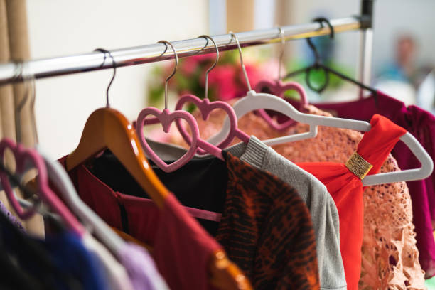 istock Many different colored women's clothes on hangers in a store 1596636683