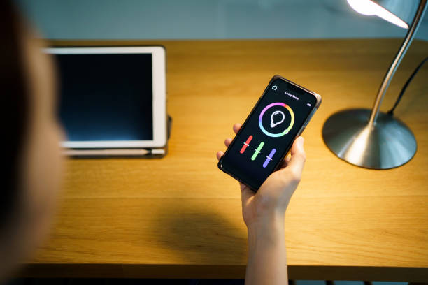 istock Woman using smart home automation application on smartphone. 1596653754