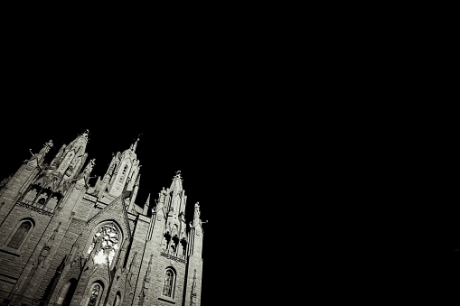 A low angle shot of the majestic Temple of the Sacred Heart of Jesus under a black sky in Barcelona, Spain