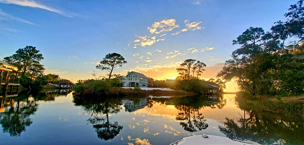 Sunset reflecting in the calm water of a canal, Orange Beach, Alabama in May
