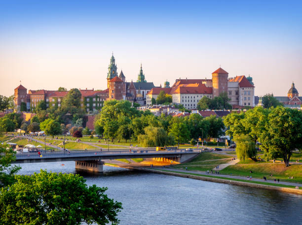 Krakow, Poland - May 5, 2018: Wawel castle and cathedral, Vistula river, Podwawelski bridge, trees and promenades in summer. Aerial view