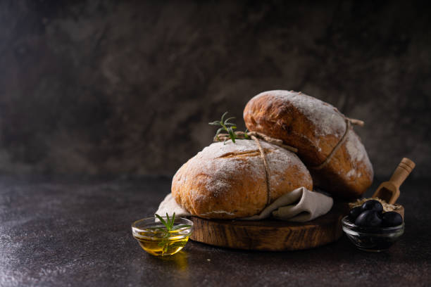 istock Fresh organic homemade artisan ciabatta bread on dark rustic background. sourdough bread 1596768491