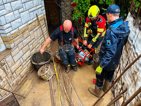 Nozice, Slovenia - August 5, 2023: Voluntary fire brigade from Lukovica town helping residents of Nozice village pumping water after severe flood.