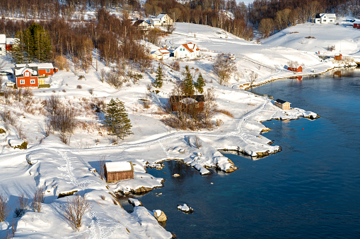 Country side, colorful houses under the Saltstraumen Bridge in the fjord Saltfjorden in Bodo territory in Nordland country, Norway. There is a small strait with one of the strongest tidal currents with whirlpools or Vortices in the world.