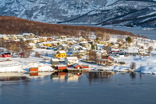Country side, colorful houses under the Saltstraumen Bridge in the fjord Saltfjorden in Bodo territory in Nordland country, Norway. There is a small strait with one of the strongest tidal currents with whirlpools or Vortices in the world.