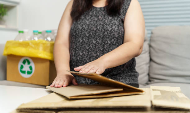 istock Home recycle eco zero waste concept Woman using recycle paper box. Stacking brown cardboard box eco friendly packaging made of recyclable raw materials. 1596839791