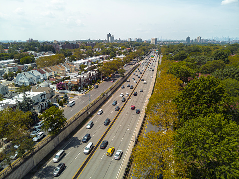 Morning traffic on Grand Central Parkway in Queens, New York: Aerial view of cars in residential area