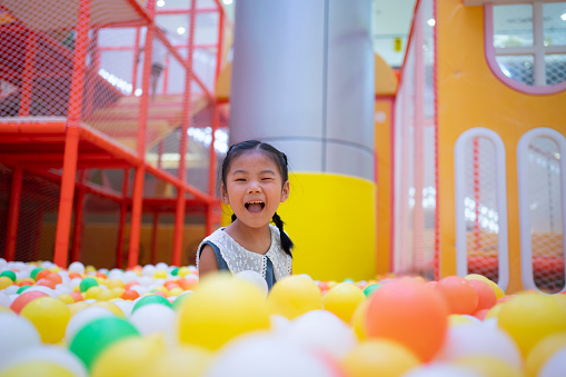 Asian little girl playing happily in the amusement park