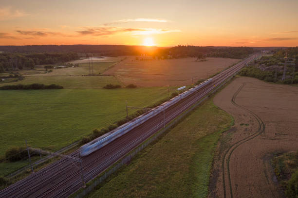 istock Train in a landscape of fields at sunset 1596891082