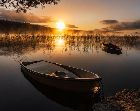 Boats lying on calm lake at sunrise