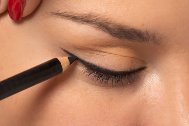woman applying cosmetic pencil on the eye stock photo