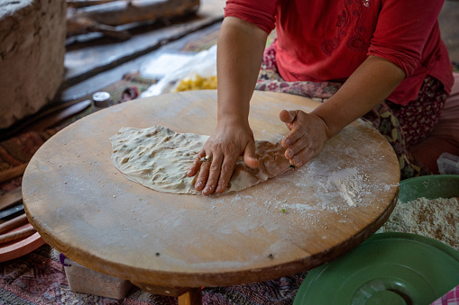 Hands of Turkish cook preparing potato and cheese gozleme on wooden table. Traditional stuffed pancakes in Alanya, Turkey. High quality photo