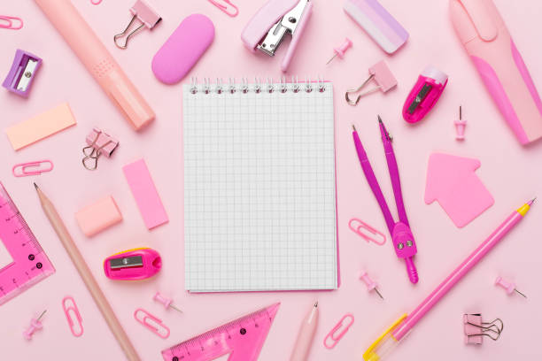 istock Pink school stationery with notebook on color backgroung, top view 1596975282