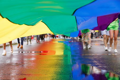 Brighton, England - August 5th 2023: The infamous rainbow flag makes its way from the Brighton Pier into the streets. The Brighton & Hove Pride Parade 2023 begins in wet and rainy conditions on August 05, 2023, in Brighton, England.