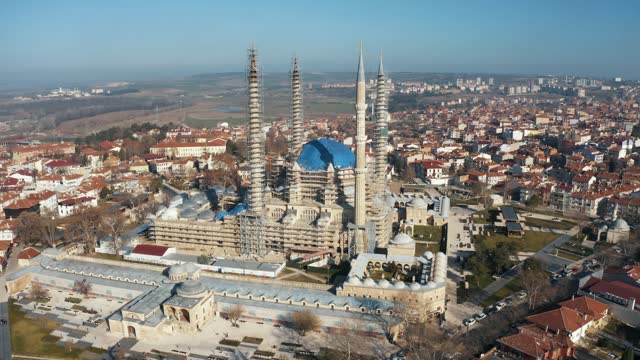 4K aerial wide angle drone footage of Selimiye Mosque in Edirne in daylight. Scaffolds around buttresses, upper walls and minarets of Selimiye Mosque for renovation stock video.