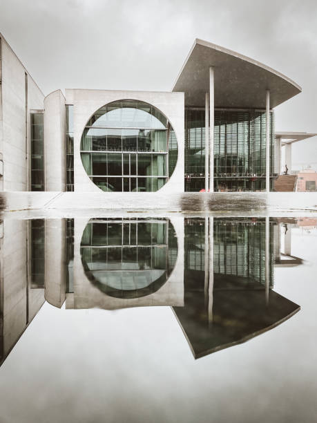 Berlin, Germany - October 14, 2021: Marie-Elisabeth-Lueders House with a reflecting puddle against cloudy sky