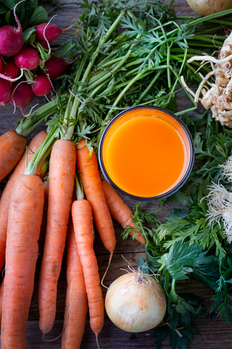 Healthy Carrot Juice (selective focus) on wooden background (close-up shot)