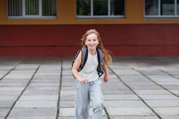 happy little girl run from school with school bag. back to school. - secondary action imagens e fotografias de stock
