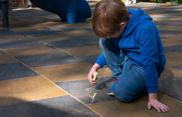 istock A boy draws with crayons on the playground 1597104050