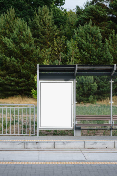 Vertical front shot of public bus stop for city transport with white canvas on billboard or lightbox. Station with template placard for commercial advertising. Urban infrastructure, commercial, promo