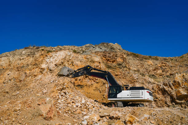 Hydraulic crawler excavator extracting stone in quarry at work