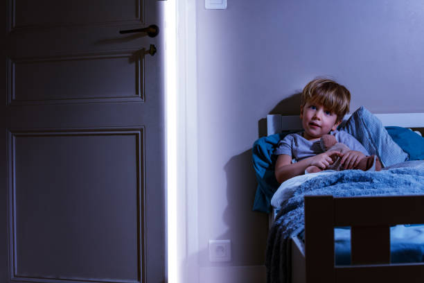 istock Happy calm boy sit in bed hold plush toy covered with blanket 1597365712