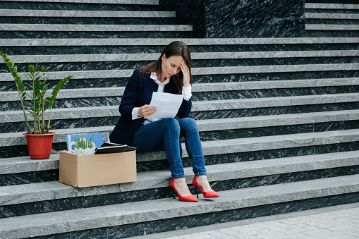 Silent Contemplation Upset Woman Reflecting on Dismissal, Sitting on Stair. The Dismissal Revelation Worried Woman Reading the Letter