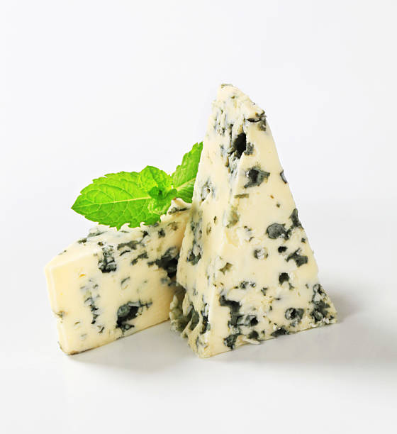 blue cheese two pieces of a ripe blue cheese decorated with mint roquefort cheese stock pictures, royalty-free photos & images