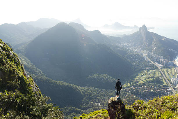 Man looking at Rio de Janeiro from above Man looking at Rio de Janeiro from above, shot from Pedra da Gavea. travel destinations 20s adult adventure stock pictures, royalty-free photos & images