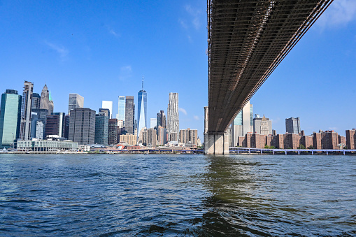 Skyline of Manhattan, New York. Downtown financial district on a clear sky day. Under Brooklyn Bridge view from Dumbo, Brooklyn.