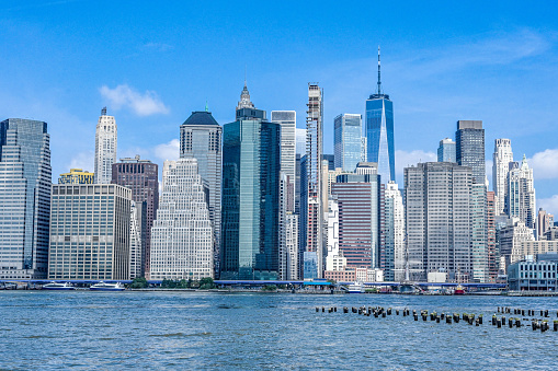 Skyline of Manhattan, New York. Downtown financial district and Freedom tower on a clear sky day. River in the foreground.