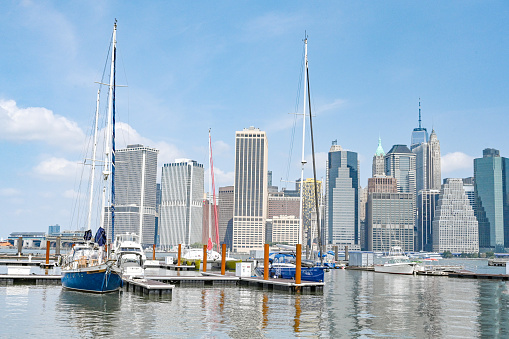 Skyline of Manhattan, New York. Downtown financial district on a clear sky day. Boats at the Marina. Reflection in Hudson / East river. Beautiful summer day for sailing activities.