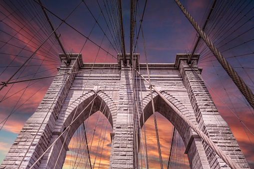 Brooklyn Bridge in Manhattan New York City with orange sky.