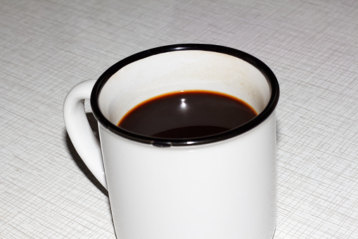 Cup of hot black coffee on the table