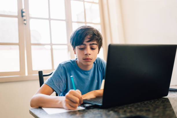 istock Pre teen boy doing his homework 1597494107