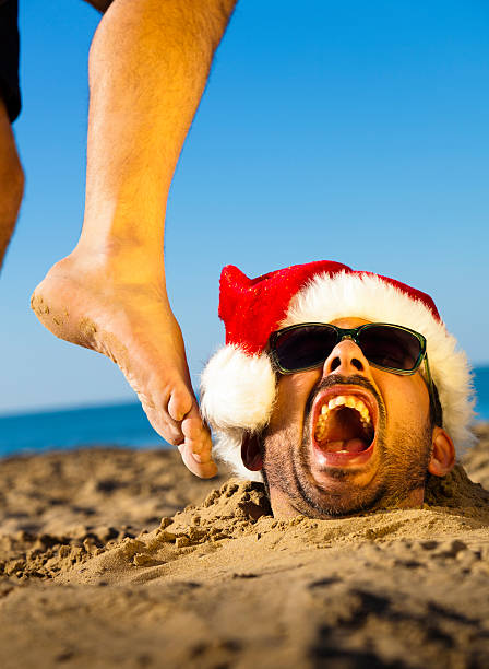 Man with Santa Claus Hat on the Beach. Humor. stock photo