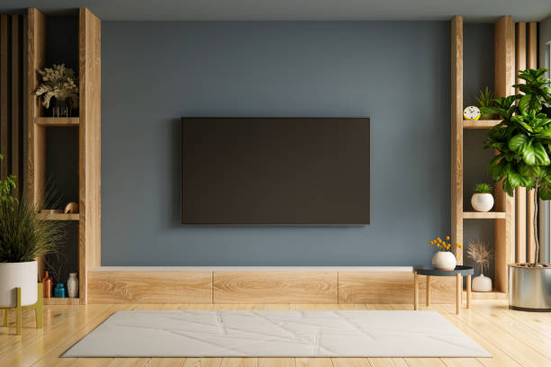 istock Tv and cabinet in modern empty room on empty dark wall background. 1597535761