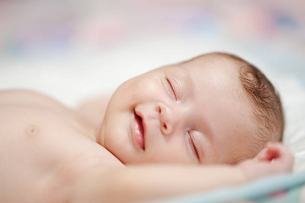 美しい笑顔で赤ちゃんの夢 - 赤ちゃん　寝る ストックフォトと画像