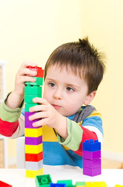istock Young boy builds a tower with connecting blocks 159754569